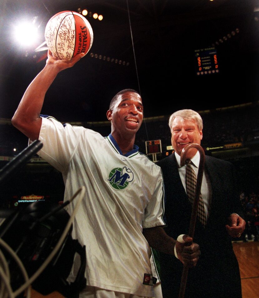 NBA Iron Man A.C. Green holds up an autographed game ball and walks with a cane given to him...