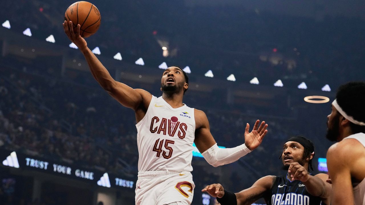 Cleveland Cavaliers guard Donovan Mitchell (45) goes to the basket past Orlando Magic center Wendell Carter Jr. (34) in the first half of an NBA basketball game Sunday, March 16, 2025, in Cleveland. (AP Photo/Sue Ogrocki)