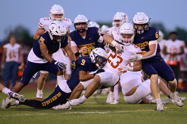 Mead’s Ryan St. Aubin, center, is brought down by Frederick’s...