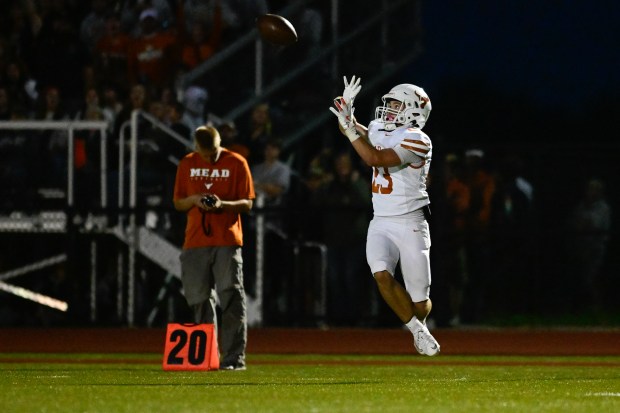 Mead’s Ryan St. Aubin completes the pass and runs in...