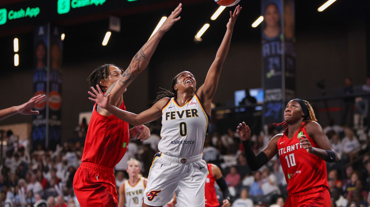 Indiana Fever guard Kelsey Mitchell (0) shoots past Atlanta Dream center Brittney Griner (42) and guard Rhyne Howard (10) in the third quarter during game one of round one for the 2025 WNBA Playoffs at Gateway Center Arena at College Park.