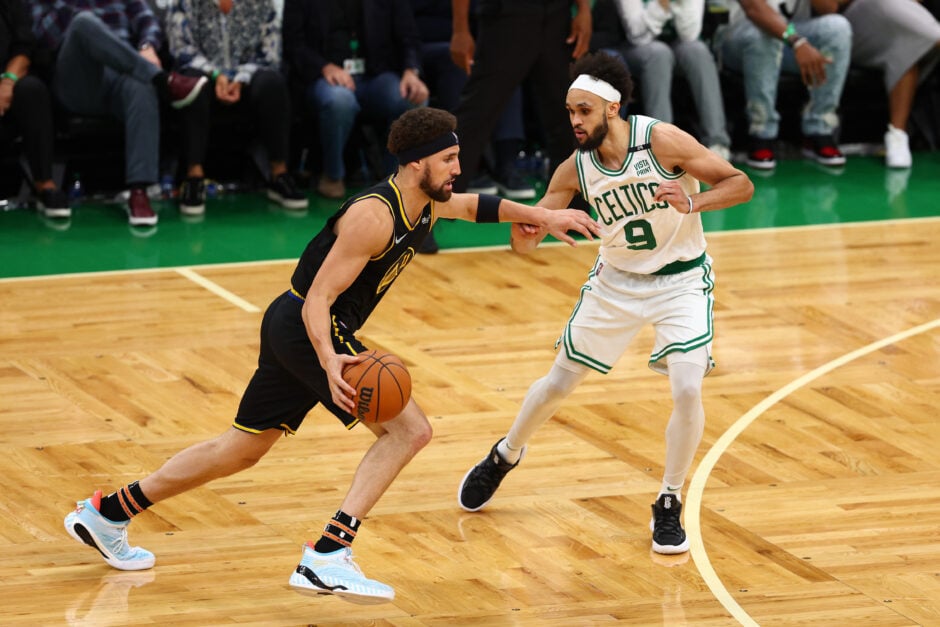 Klay Thompson #11 of the Golden State Warriors drives past Derrick White #9 of the Boston Celtics in the fourth quarter during Game Four of the 2022 NBA Finals at TD Garden.