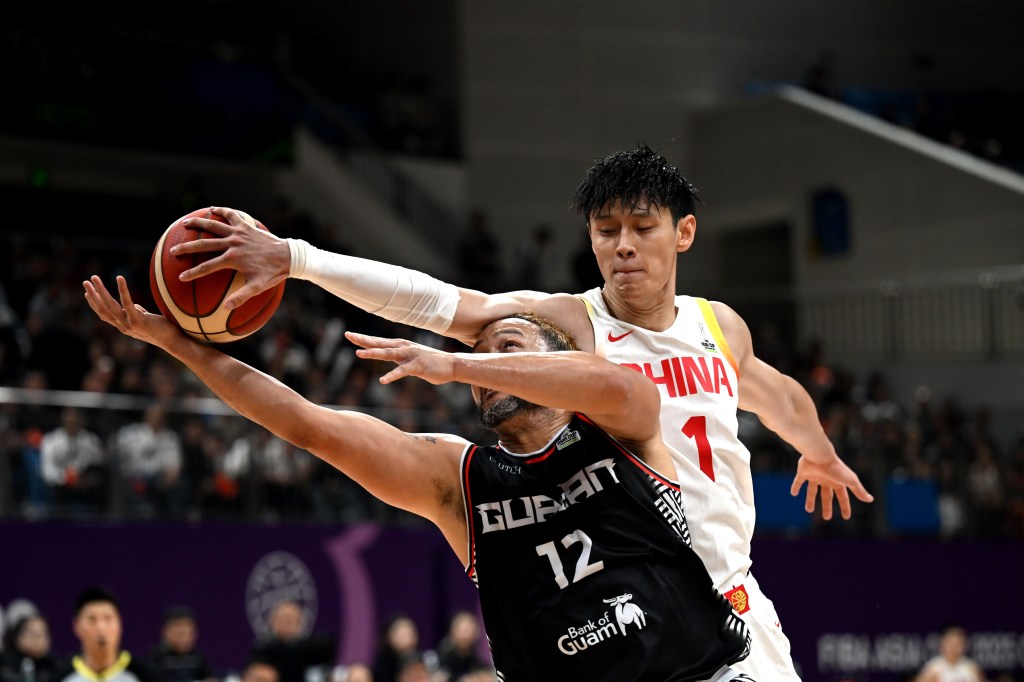 Zeng Fanbo R of China vies with Joseph Blas Jr. of Guam during a FIBA Asia Cup Qualifier 