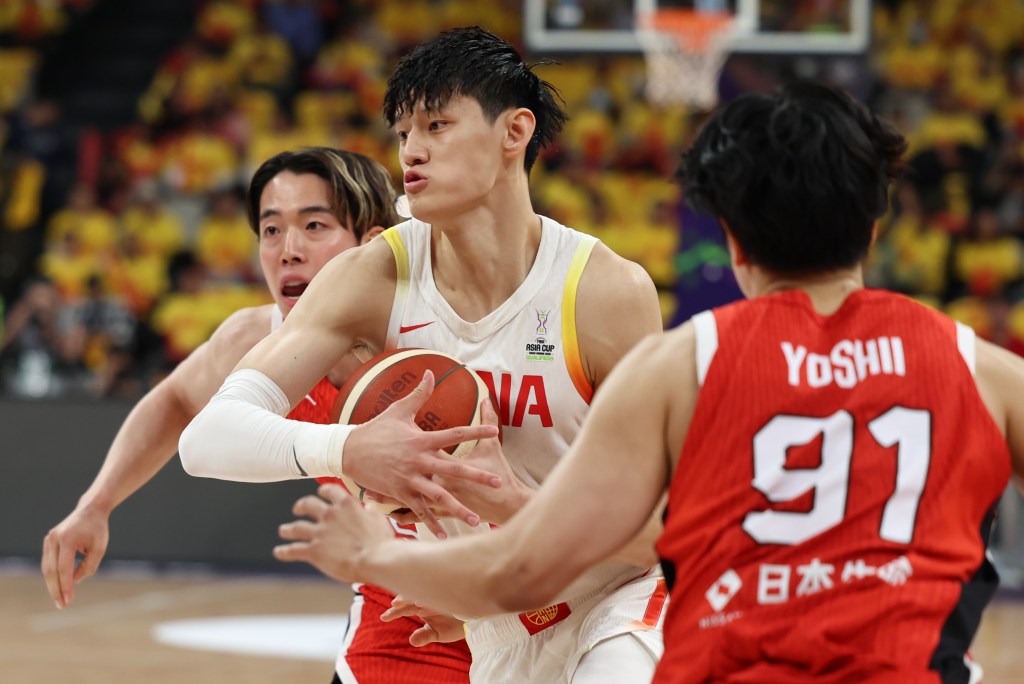 Zeng Fanbo of China competes for the ball against two Japanese players.