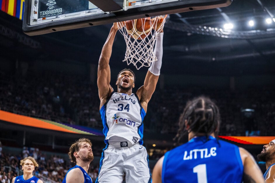 Giannis Antetokounmpo of Greece hangs on the rim in celebration after a thunderous dunk during the FIBA EuroBasket 2025 Third Place game between Greece and Finland.