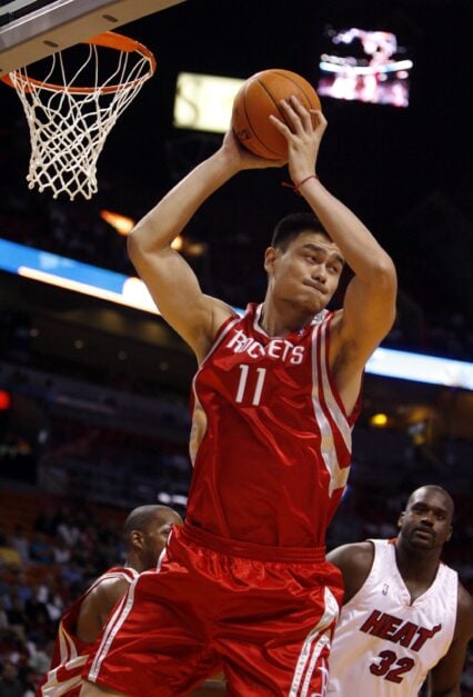 Yao Ming grabs a rebound for the Rockets. Shaquille O'Neal in the background