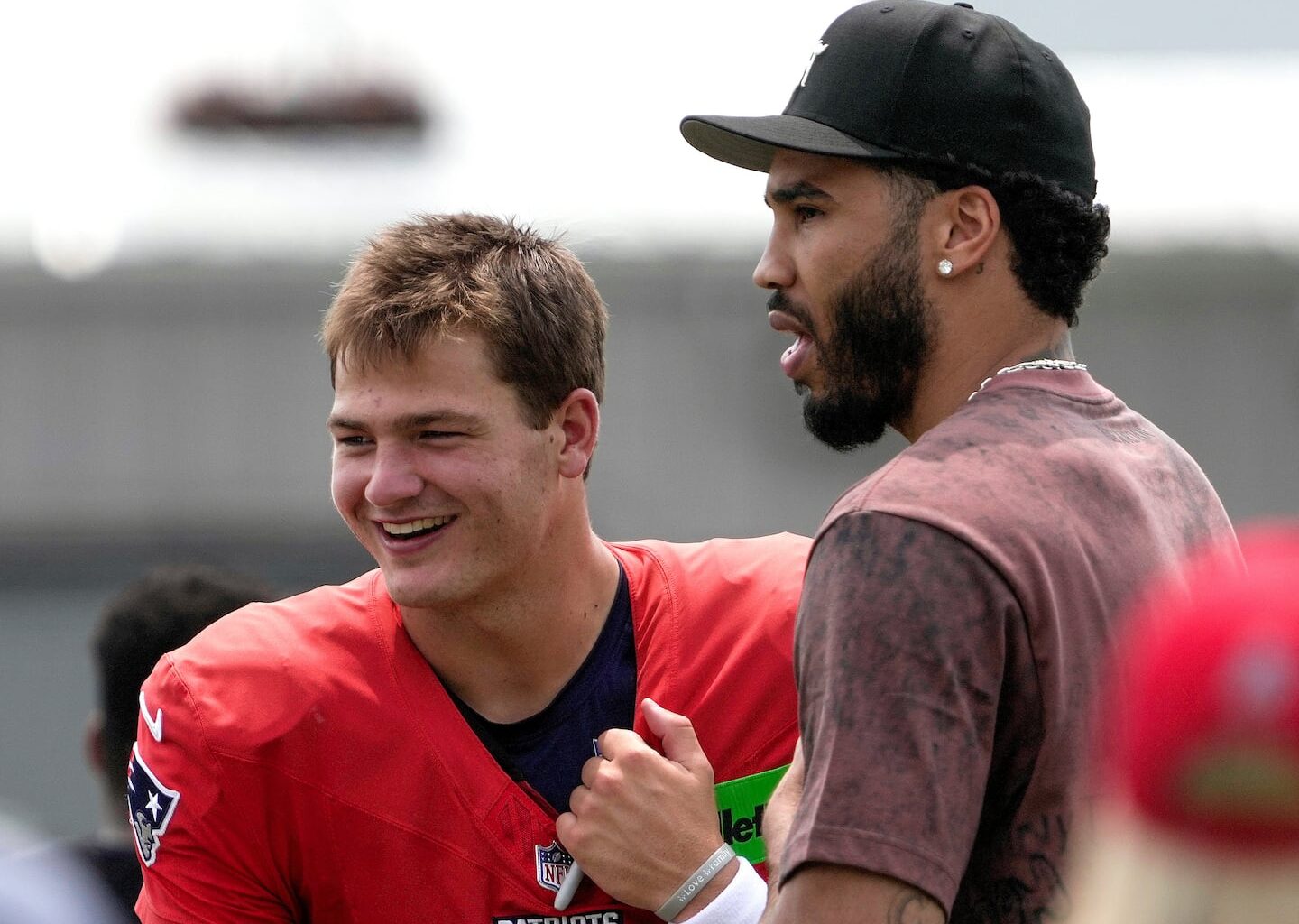 The Celtics' Jayson Tatum (right), who is walking normally again after tearing his Achilles' tendon in the playoffs, visited with Drake Maye during Patriots training camp in August.