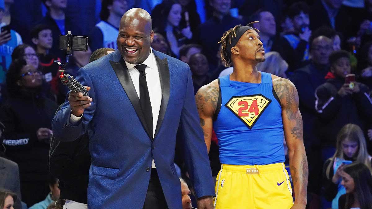 Shaquille O'Neal laughs while standing next to Los Angeles Lakers player Dwight Howard during the slam dunk contest during NBA All Star Saturday Night at United Center