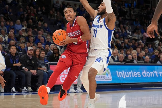 Louisiana Tech guard Sean Newman Jr., left, runs to the basket past Memphis guard Tyrese Hunter (11) during the second half of an NCAA college basketball game Wednesday, Dec. 4, 2024, in Memphis, Tenn. (AP Photo/George Walker IV)