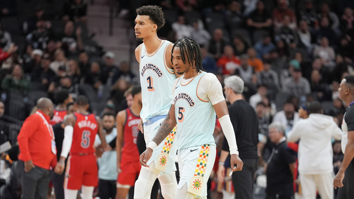 San Antonio Spurs center Victor Wembanyama (1) and guard Stephon Castle (5) walk toward the bench in the second half against the New Orleans Pelicans at Frost Bank Center. 
