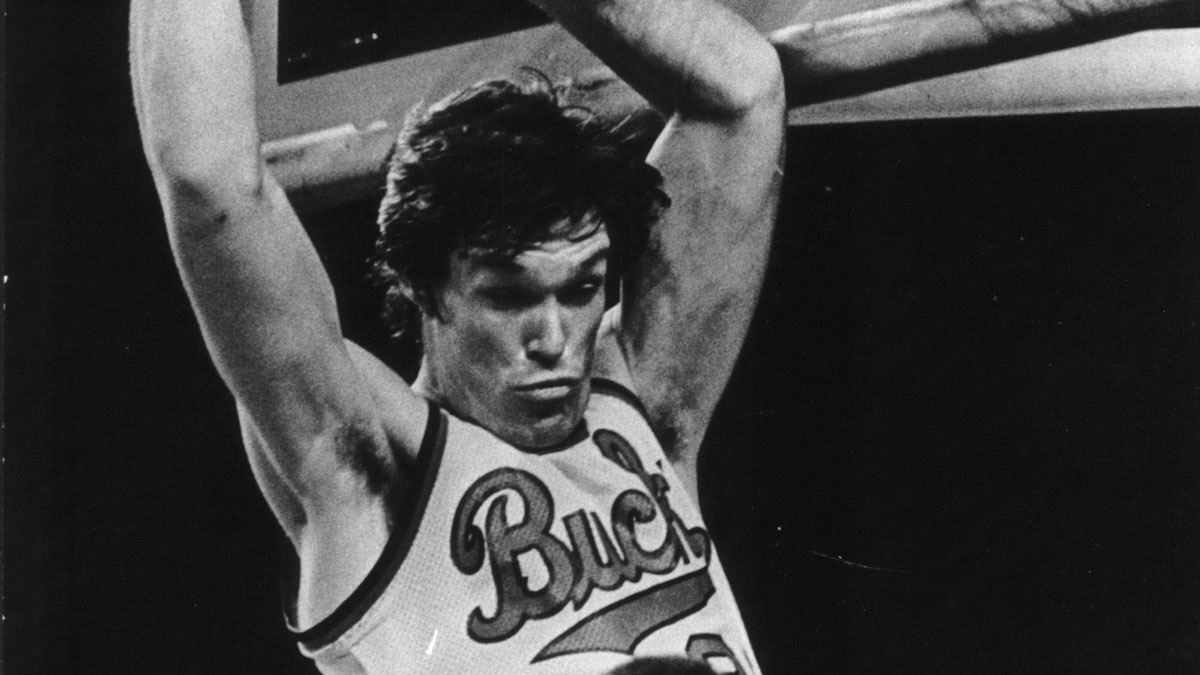 One hand clutching the rim, the Bucks Swen Nater intimidated Sam Lacey with a dunk.1977 Press Photo Swen Nater Intimidates Sam Lacey With A Dunk