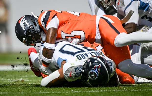 Jahdae Barron (23) of the Denver Broncos tackles Tony Pollard...