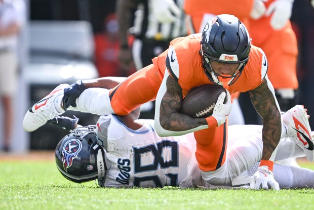 Evan Engram (1) of the Denver Broncos fights for yards...