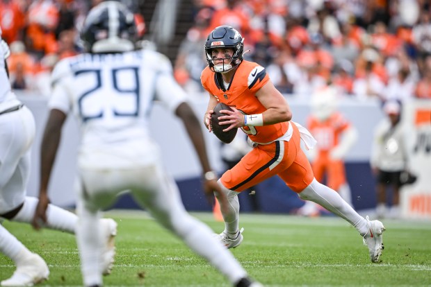Bo Nix (10) of the Denver Broncos rolls out as...
