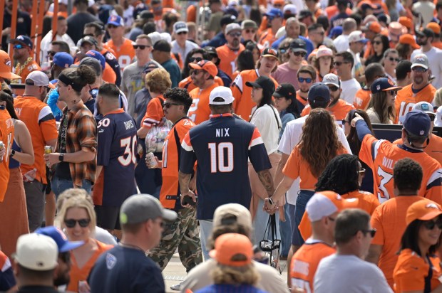 Denver Broncos fans walk through the tailgate party outside Empower...