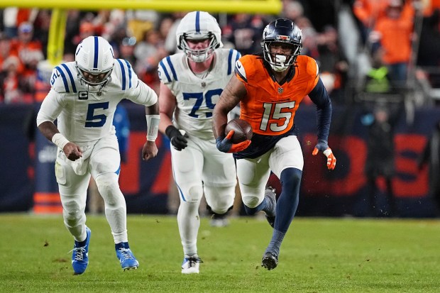 Denver Broncos linebacker Nik Bonitto (15) intercepts the ball for a touchdown in the fourth quarter against the Indianapolis Colts during a game on Dec. 15, 2024 in Denver. (AP Photo/Bart Young)
