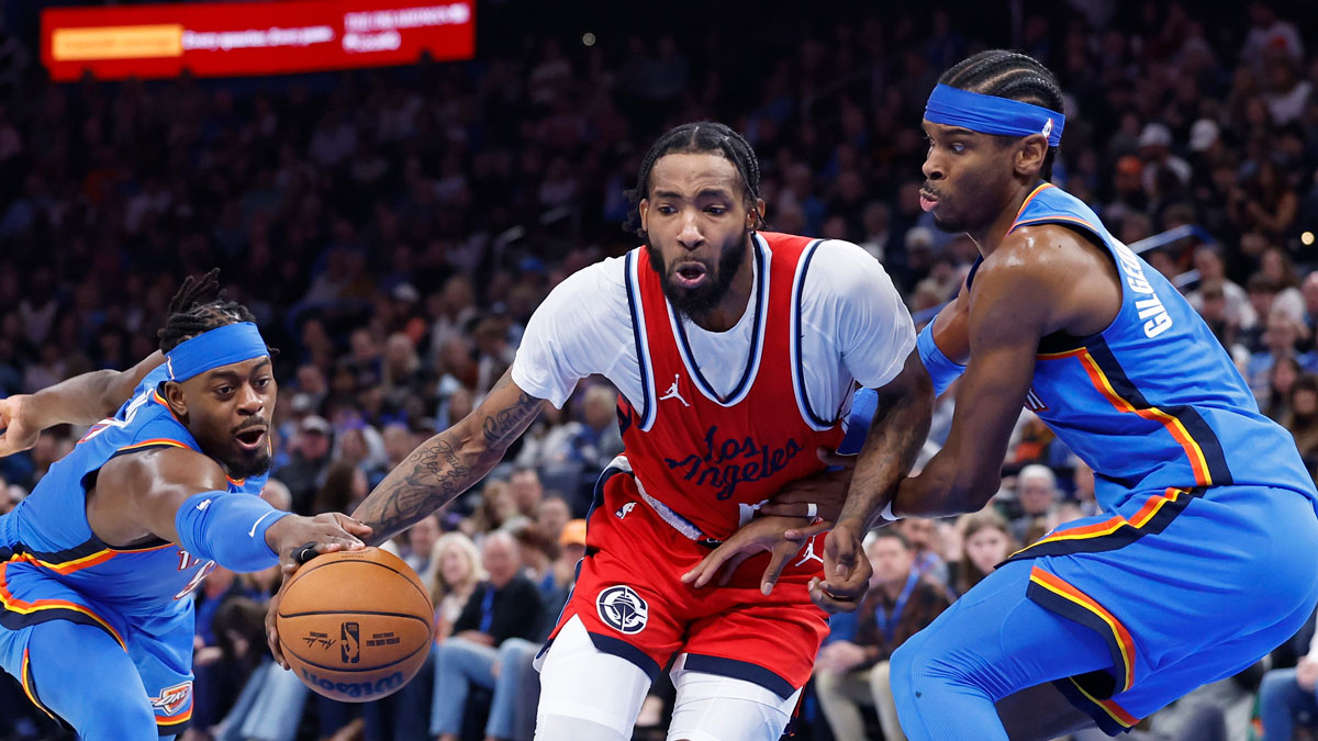 Thunder guard Luguentz Dort (5) steals the ball from Los Angeles Clippers forward Derrick Jones Jr. (55) as Oklahoma City Thunder guard Shai Gilgeous-Alexander (2) defends during the second half at Paycom Center