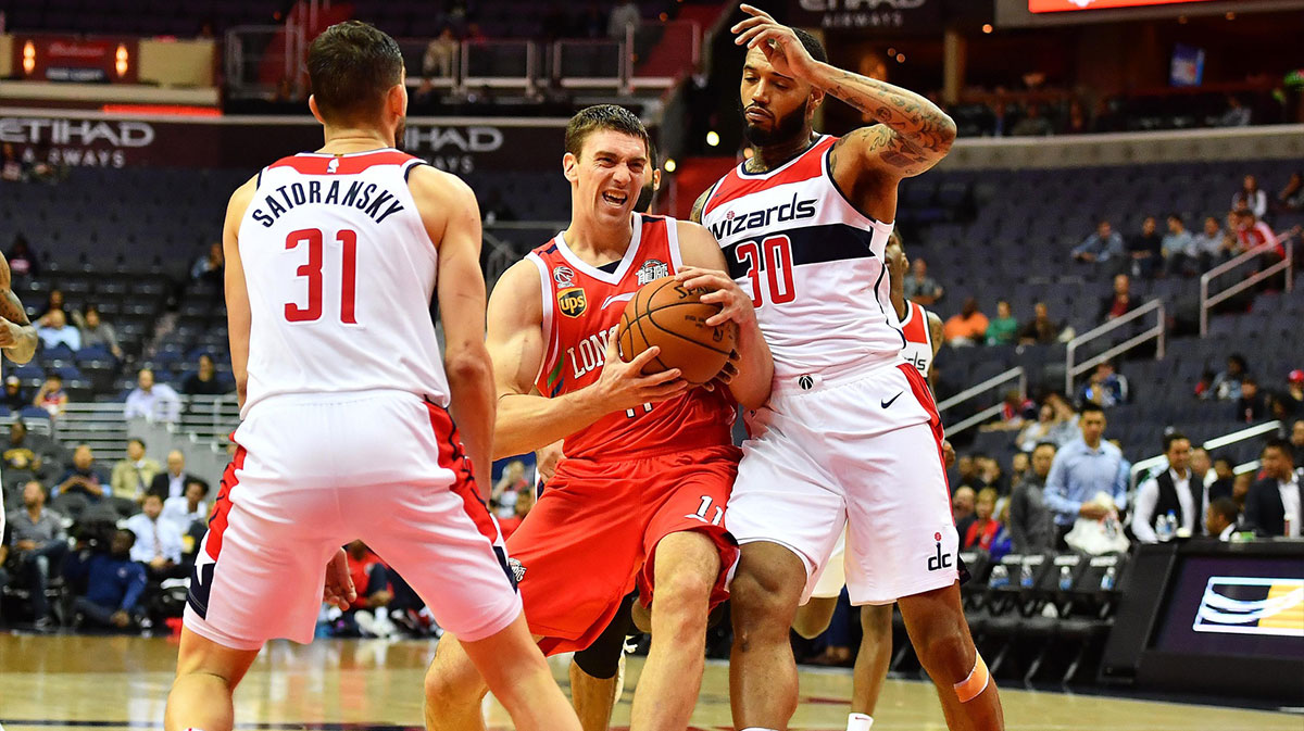 Guangzhou Long-Lions forward Tyler Hansbrough (11) is fouled by Washington Wizards forward Mike Scott (30) as guard Tomas Satoransky (31) looks on during the second half at Capital One Arena.