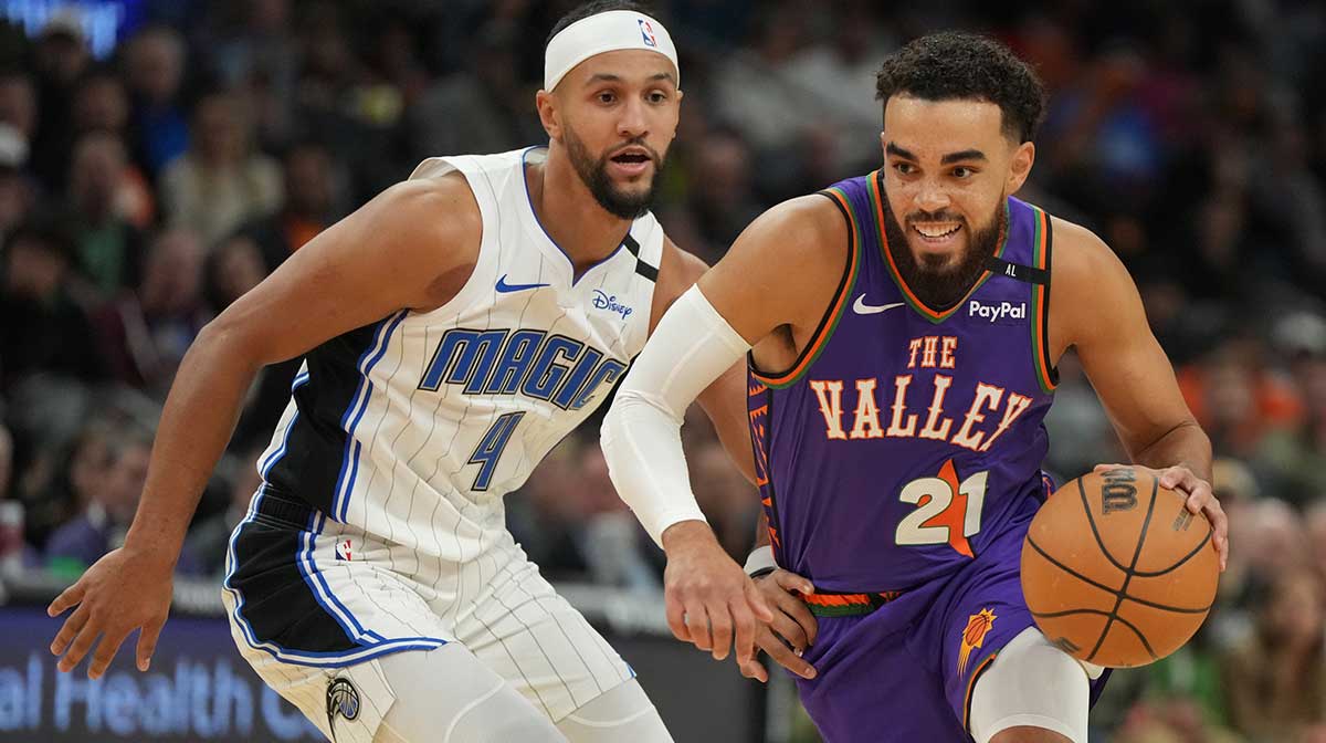 Phoenix Suns guard Tyus Jones (21) drives on Orlando Magic guard Jalen Suggs (4) during the first half of an NBA game at Footprint Center.