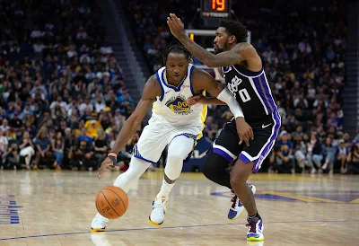Jonathan Kuminga, Golden State Warriors, drives the ball past defender Malik Monk
