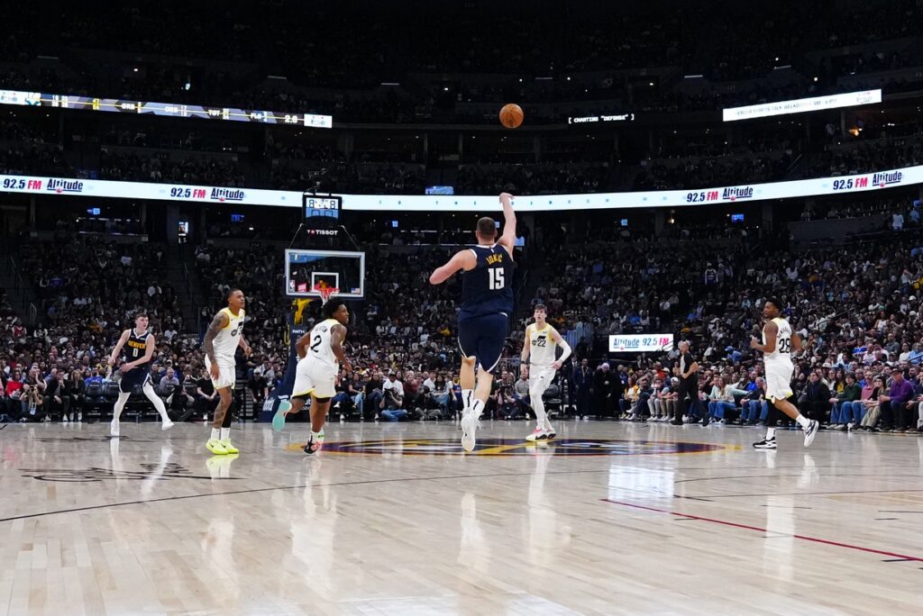 Mar 28, 2025; Denver, Colorado, USA; Denver Nuggets center Nikola Jokic (15) shoots a successful three point basket at the end of the second quarter against the Utah Jazz at Ball Arena. Mandatory Credit: Ron Chenoy-Imagn Images