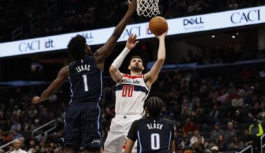 Apr 3, 2025; Washington, District of Columbia, USA; Washington Wizards forward Tristan Vukcevic (00) shoots the ball as Orlando Magic forward Jonathan Isaac (1) defends in the second half at Capital One Arena. Mandatory Credit: Geoff Burke-Imagn Images
