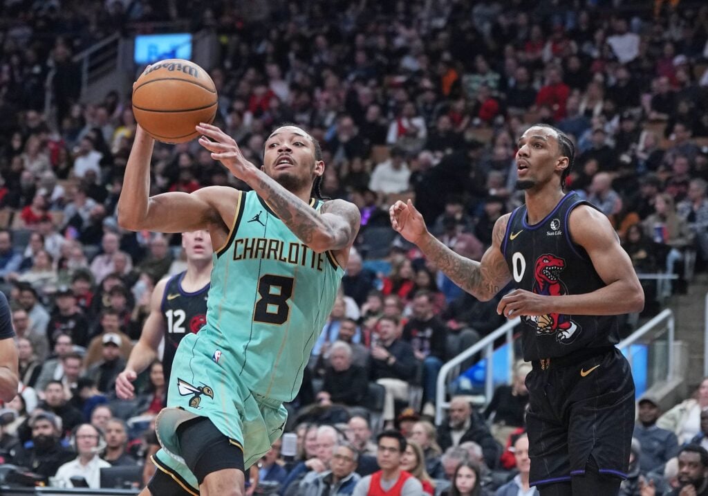 Apr 9, 2025; Toronto, Ontario, CAN; Charlotte Hornets guard Nick Smith Jr. (8) passes against Toronto Raptors guard A.J. Lawson (0) during the third quarter at Scotiabank Arena. Mandatory Credit: Nick Turchiaro-Imagn Images
