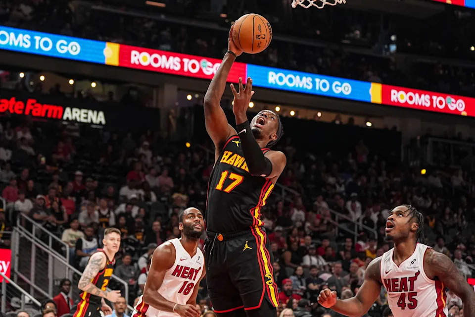Apr 18, 2025; Atlanta, Georgia, USA; Atlanta Hawks forward Onyeka Okongwu (17) shoots at the basket behind Miami Heat guard Davion Mitchell (45) during the first half at State Farm Arena. Mandatory Credit: Dale Zanine-Imagn Images