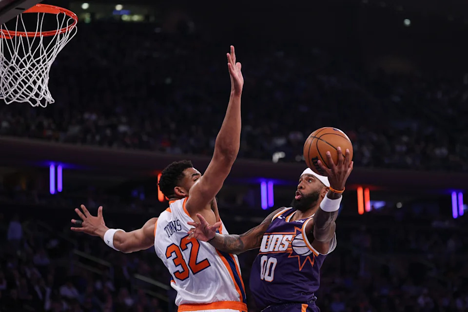 Apr 6, 2025; New York, New York, USA; Phoenix Suns forward Royce O'Neale (00) shoots the ball against New York Knicks center Karl-Anthony Towns (32) during the first half at Madison Square Garden. Mandatory Credit: Vincent Carchietta-Imagn Images