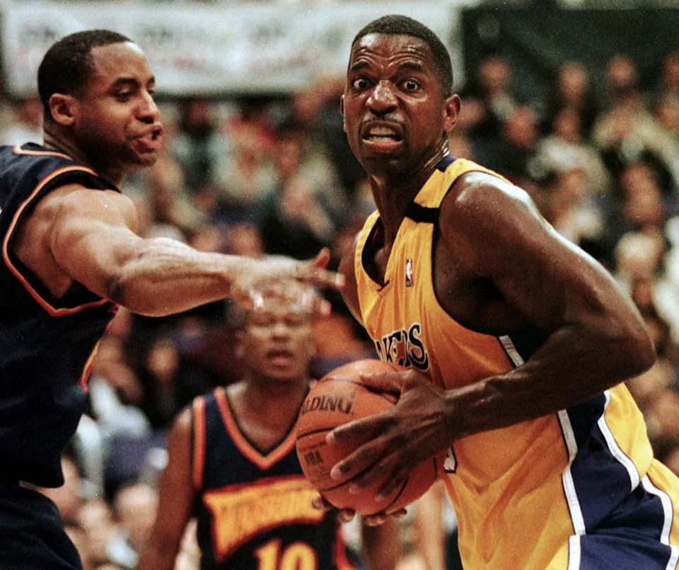 LOS ANGELES, UNITED STATES: A.C. Green (R) of the Los Angeles Lakers grabs a rebound past Jason Caffey of the Golden State Warriors 01 December 1999 in Los Angeles, Ca. Green recently became the all-time NBA record holder for most consecutive games played.  AFP PHOTO/Vince BUCCI (Photo credit should read Vince Bucci/AFP via Getty Images)