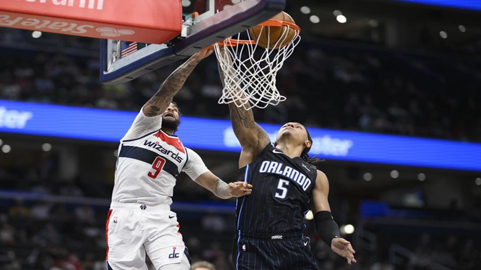 Washington Wizards forward Justin Champagnie (9) goes to the basket against Orlando Magic forward Paolo Banchero (5) during the first half of an NBA basketball game, Thursday, April 3, 2025, in Washington. (AP Photo/Nick Wass)