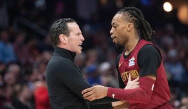 Cleveland Cavaliers forward Jaylon Tyson, left, talks with Donovan Mitchell, center, and Evan Mobley, right, who did not dress for the game, in the first half of an NBA basketball game against the Indiana Pacers Sunday, April 13, 2025, in Cleveland. (AP Photo/Sue Ogrocki)
