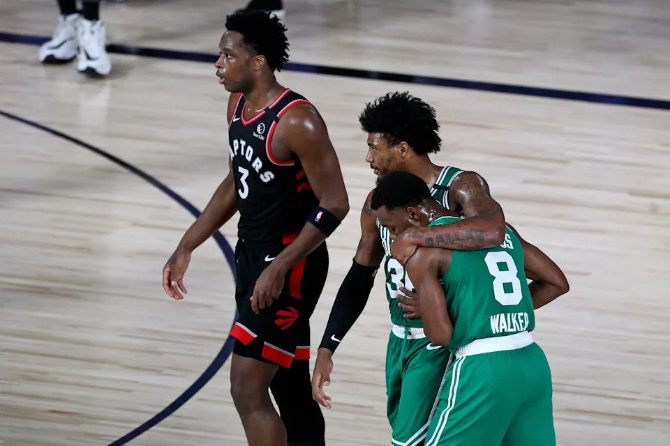 Sep 3, 2020; Lake Buena Vista, Florida, USA; Boston Celtics guard Kemba Walker (8) and Boston Celtics guard Marcus Smart (36) embrace as they walk past Toronto Raptors forward OG Anunoby (3) during the first half in game three of the second round of the 2020 NBA Playoffs at ESPN Wide World of Sports Complex. Mandatory Credit: Kim Klement-USA TODAY Sports