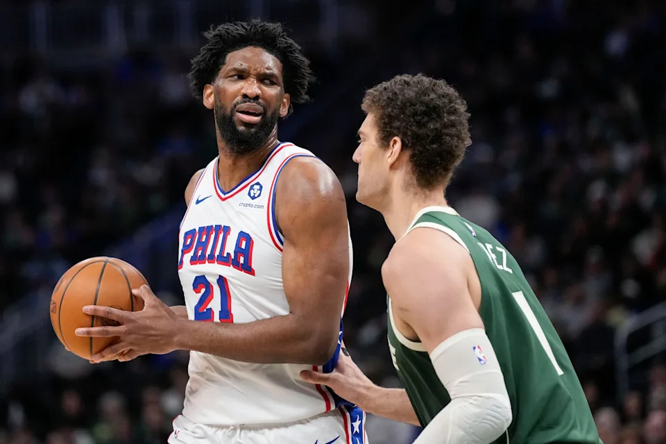 Feb 9, 2025; Milwaukee, Wisconsin, USA; Philadelphia 76ers center Joel Embiid (21) holds the ball as Milwaukee Bucks center Brook Lopez (11) defends during the second quarter at Fiserv Forum. Mandatory Credit: Jeff Hanisch-Imagn Images