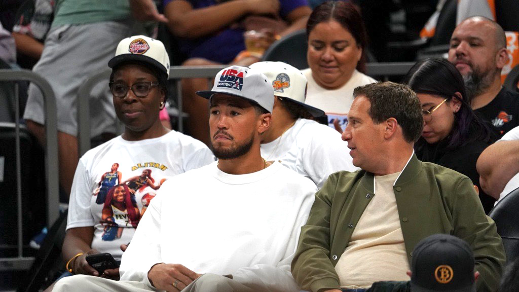 Phoenix Suns guard Devin Booker next to Suns and Mercury owner Mat Ishbia as Mercury played host to...