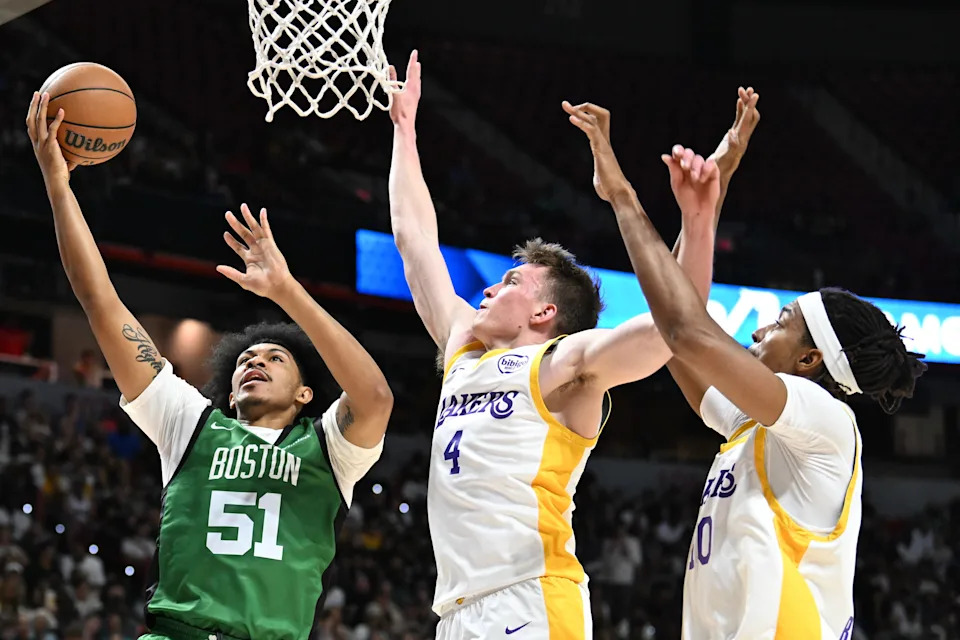 LAS VEGAS, NEVADA - JULY 15: Ron Harper Jr. #51 of the Boston Celtics drives to the basket against Dalton Knecht #4 and Moses Brown #40 of the Los Angeles Lakers in the first half of a 2024 NBA Summer League game at the Thomas & Mack Center on July 15, 2024 in Las Vegas, Nevada. The Celtics defeated the Lakers 88-74. NOTE TO USER: User expressly acknowledges and agrees that, by downloading and or using this photograph, User is consenting to the terms and conditions of the Getty Images License Agreement. (Photo by Candice Ward/Getty Images)