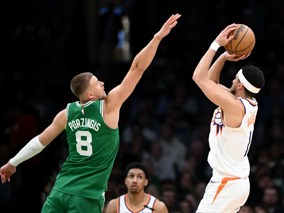 Devin Booker #1 of the Phoenix Suns attempts a basket against Kristaps Porzingis #8 of the Boston Celtics during the second quarter at the TD Garden on April 04, 2025, in Boston.