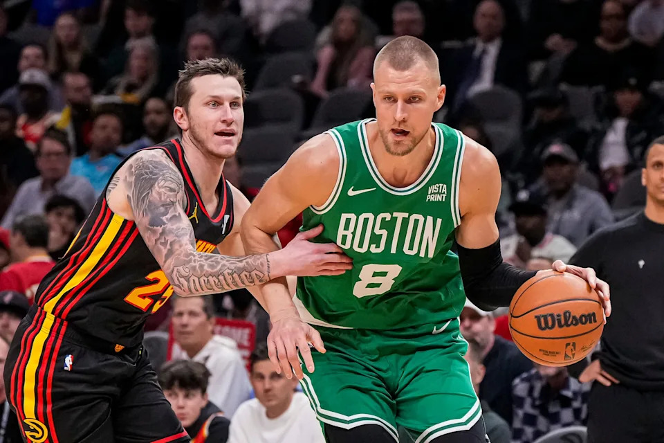 Mar 28, 2024; Atlanta, Georgia, USA; Boston Celtics center Kristaps Porzingis (8) dribbles against Atlanta Hawks guard Garrison Mathews (25) during the first half at State Farm Arena. Mandatory Credit: Dale Zanine-USA TODAY Sports