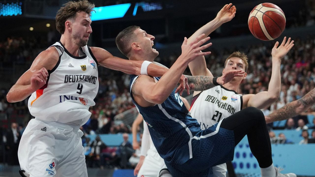 Germany's Franz Wagner, left, Slovenia's Alen Omic, centre, Germany's Justus Hollatz in action during the Eurobasket, European Basketball Championship quarter final match between Germany and Slovenia at the Riga Arena in Riga, Latvia, Wednesday, Sept. 10, 2025. (AP Photo/Sergei Grits)