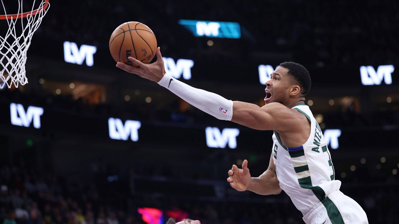 Milwaukee Bucks forward Giannis Antetokounmpo, right, goes to the basket against the Utah Jazz during the first quarter of an NBA basketball game, Monday, Jan. 27, 2025, in Salt Lake City. (AP Photo/Rob Gray)