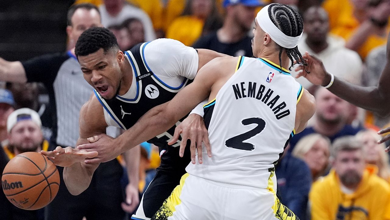 Milwaukee Bucks' Giannis Antetokounmpo, left, dribbles as Indiana Pacers' Andrew Nembhard (2) defends during the first half of a first-round NBA basketball playoff game, Saturday, April 19, 2025, in Indianapolis.