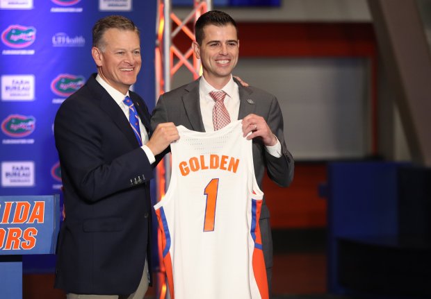 University of Florida athletic director Scott Stricklin, left, presents Gators jersey to Todd Golden when he hired Golden three years ago. (Tim Casey/Courtesy of UAA).