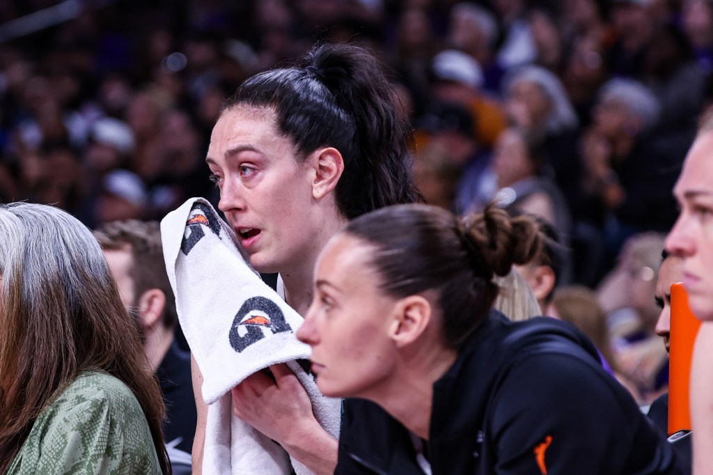 Breanna Stewart of the New York Liberty wiping sweat from her face on the bench.