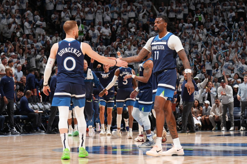 Minnesota Timberwolves players Donte DiVincenzo and Naz Reid high-five.