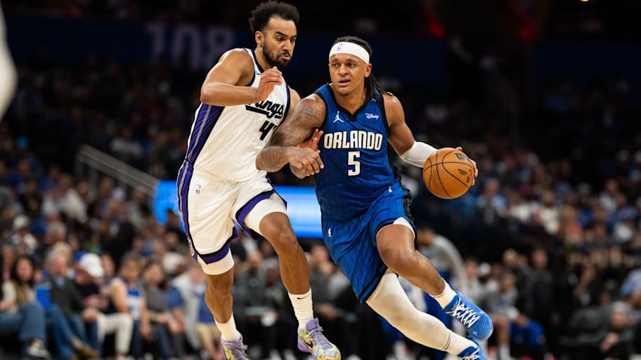 Magic forward Paolo Banchero dribbles past Kings forward Trey Lyles.