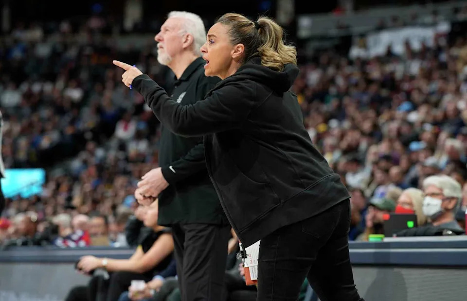 San Antonio Spurs assistant coach Becky Hammon, front, talks to players, next to coach Gregg Popovich during the first half of the team's NBA basketball game against the Denver Nuggets on Tuesday, April 5, 2022, in Denver. (David Zalubowski, STF / Associated Press)