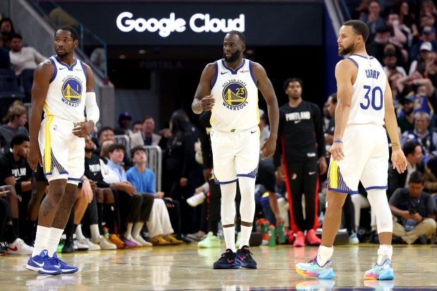 Golden State Warriors' Jonathan Kuminga (1), Golden State Warriors' Draymond Green (23) and Golden State Warriors' Stephen Curry (30) look on in the second quarter of an NBA preseason game against the Portland Trail Blazers at Chase Center in San Francisco, Calif., on Wednesday, Oct. 8, 2025. (Ray Chavez/Bay Area News Group)
