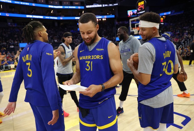 Golden State Warriors' Stephen Curry walks off the court after being named the 2024-25 Twyman-Stokes Teammate of the Year Award winner during their open practice at the Chase Center in San Francisco, Calif., on Thursday, Oct. 9, 2025. To the right tis his brother Seth Curry. (Jane Tyska/Bay Area News Group)