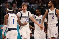 Dallas Mavericks forward Cooper Flagg (32) is congratulated by teammates Jaden Hardy (1) and...