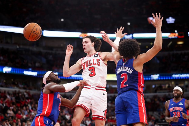 Detroit Pistons guard Cade Cunningham (2) locks arms with Chicago Bulls guard Josh Giddey (3) while he passes the ball during the first quarter of the home opener at the United Center Wednesday Oct. 22, 2025 in Chicago. (Armando L. Sanchez/Chicago Tribune)